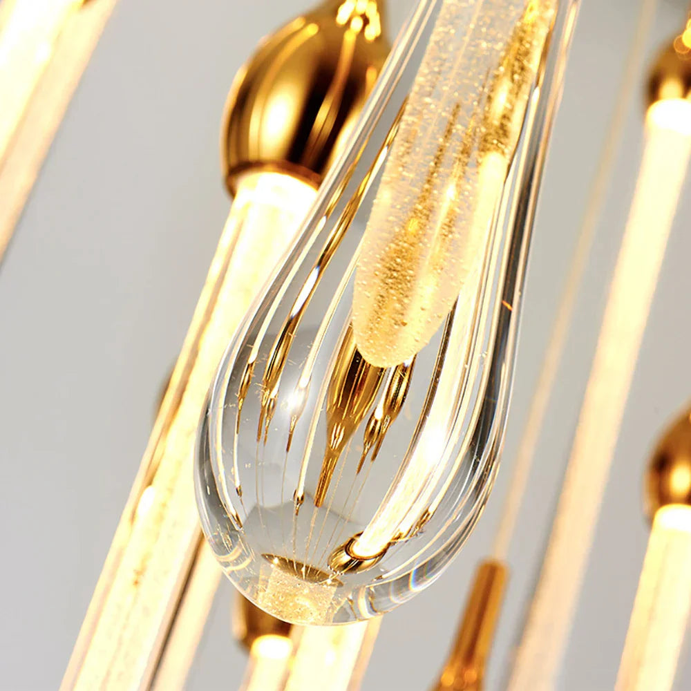 Close-up of modern gold-accented LED crystal chandelier with teardrop pendants and adjustable height.