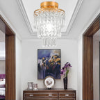 Maison Ornate’s Modern Crystal Art Deco Chandelier with a gold stainless frame hangs overhead.
