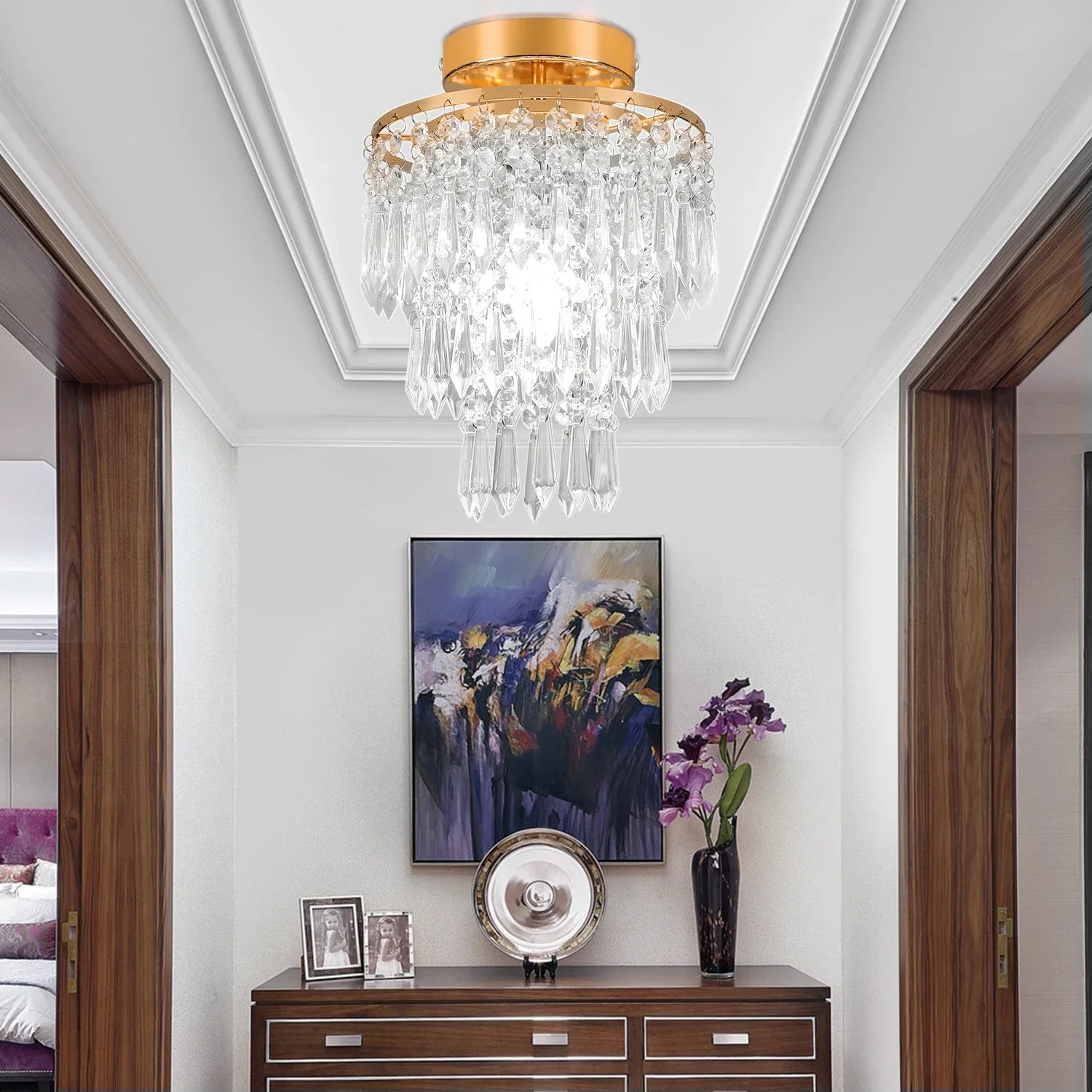 Maison Ornate’s Modern Crystal Art Deco Chandelier with a gold stainless frame hangs overhead.