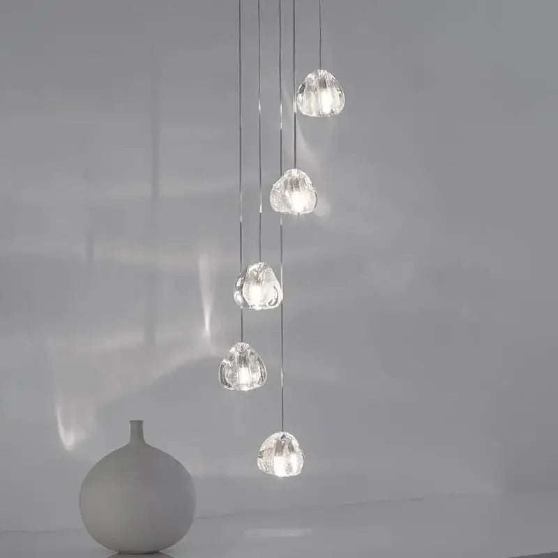 Five ornate modern rotating crystal LED chandeliers hang at various heights, sparkling with elegant reflections.