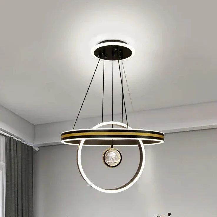 Circular crystal chandelier with LED geometric rings, suspended by black wires from a round ceiling base.