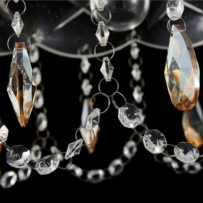 Close-up of clear and amber faceted pendants on an Art Deco crystal chandelier with LED lighting.