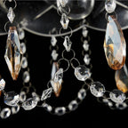 Close-up of clear and amber faceted pendants on an Art Deco crystal chandelier with LED lighting.