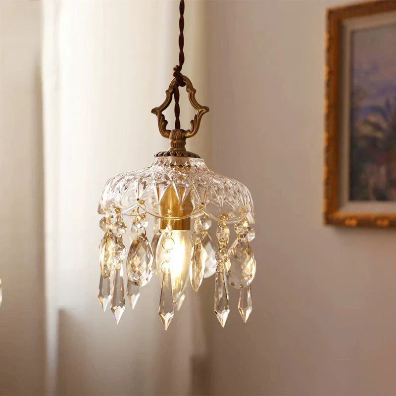 Maison Ornate Nordic Vintage Crystal and Brass Pendant Light with prisms and glass shade glowing warmly.