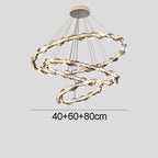 Three intertwined wavy metallic rings form a modern crystal chandelier with integrated LED lighting.