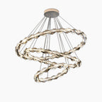 Three intertwined LED crystal rings with metallic finish, suspended by thin wires from round base.
