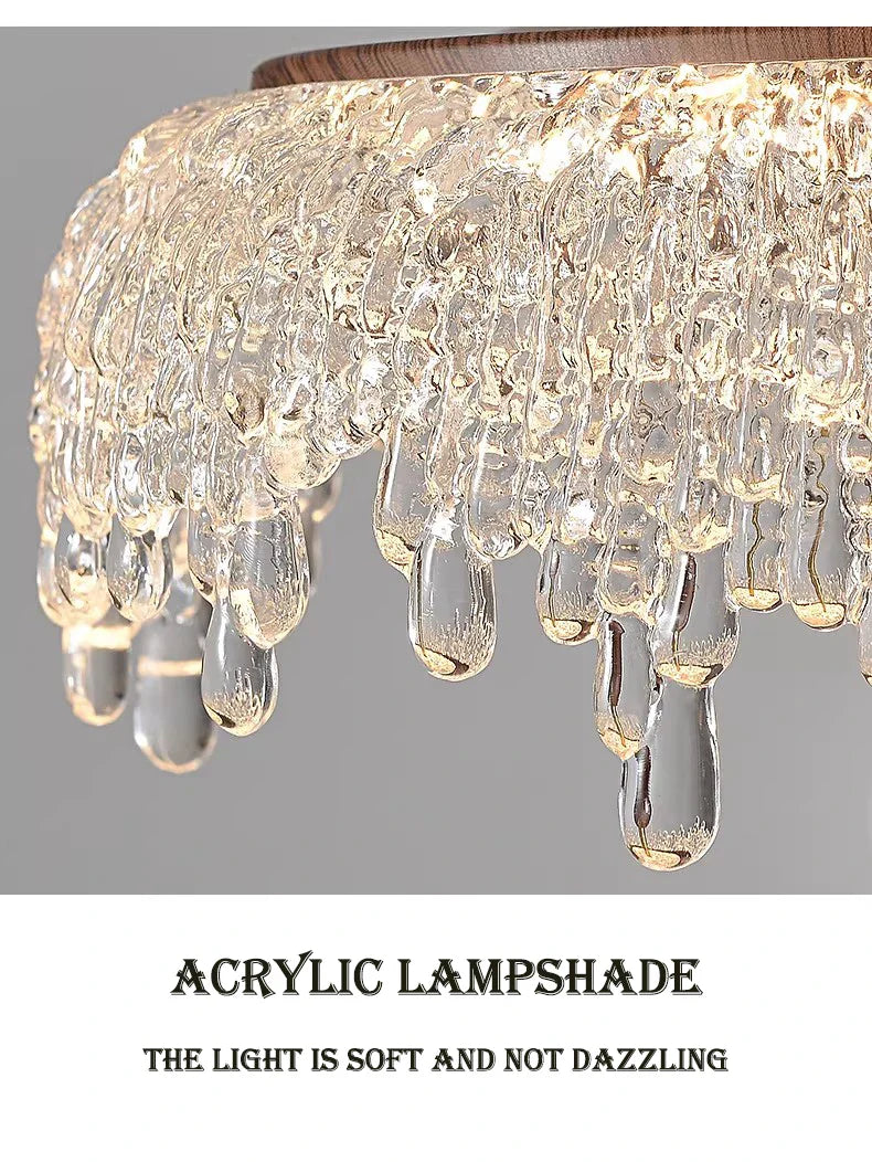 Close-up of Maison Ornate French-style chandelier with acrylic shade and sparkling crystal teardrops.
