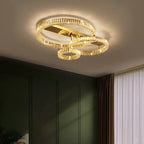 Modern chandelier with three interlocking gold rings, stainless steel frame, and radiant crystal accents.