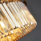 Luxurious spiral chandelier with gold-edged glass prisms reflecting warm yellow light, exuding elegance.