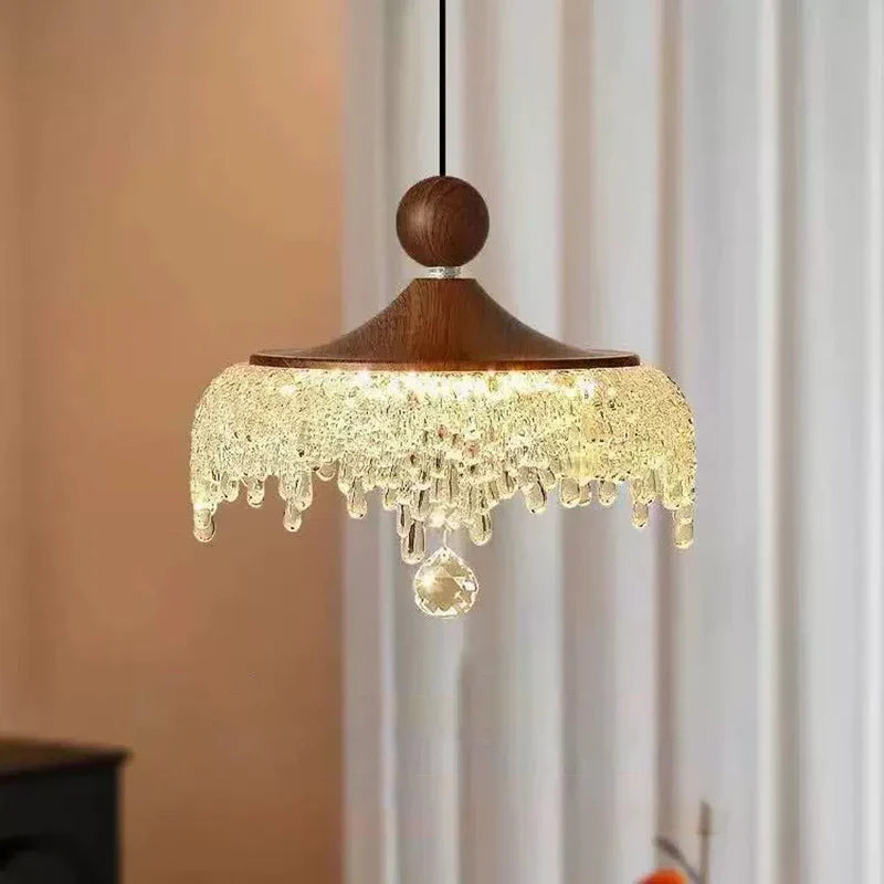 Crystal teardrop chandelier with ornate French medieval style and dome shade, exuding elegant warm illumination.