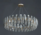 Oval chandelier with vertical crystals, metallic accents, four suspension wires, and a sleek central ring.