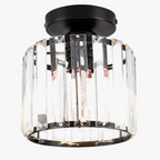 Modern black circular chandelier with vertical crystal panels and exposed bulbs; elegant flush mount design.