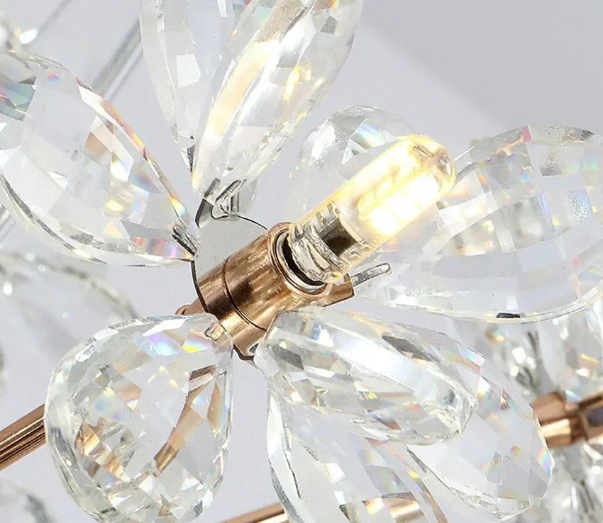 Close-up of Maison Ornate crystal dandelion chandelier with faceted teardrops and lit LED bulb.