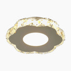 Round metallic chandelier with faceted crystal edge, emitting a warm yellowish LED glow.