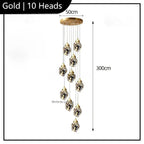 10 geometric crystal LED pendants hang from a 50 cm gold base, creating a modern chandelier.