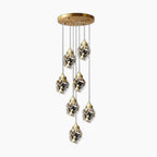 Modern gold chandelier with seven LED pendants, faceted glass shades, geometric and elegant design.