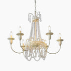 Ornate French-style chandelier with six candle lights, gold detailing, and draped crystal chains.
