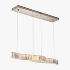 Rectangular mount chandelier with four cables and wavy vertical crystals emitting warm LED light.