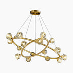 Modern chandelier with two gold rings and glass spheres suspended by thin cables.