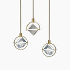 Diamond-shaped glass and gold chandelier with three pendants at varied heights, modern Nordic luxury.