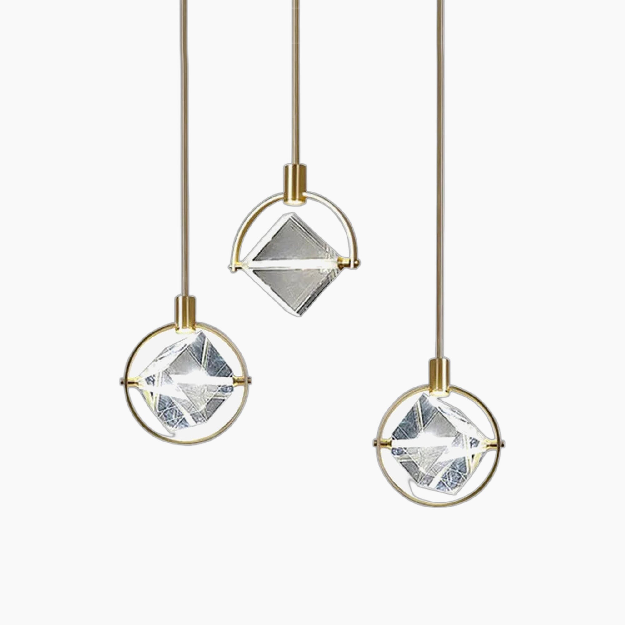 Diamond-shaped glass and gold chandelier with three pendants at varied heights, modern Nordic luxury.