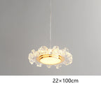 Modern crystal chandelier with circular gold frame, wavy edges, and LED lighting, suspended by thin cord.