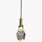 Modern minimalist gold chandelier with irregular crystal glass shade and black cord suspension.