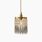 Gold circular frame chandelier with hanging crystal beads, elongated prisms, and twisted gold suspension.