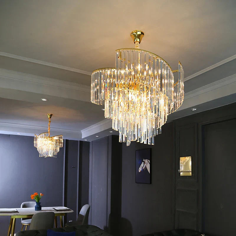 Two Maison Ornate Luxurious Spiral Crystal Gold Lustre Postmodern chandeliers emit a warm, elegant glow.