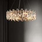 Gold chandelier with vertical glass rods, ornate design, emits warm golden light, modern decorative style.