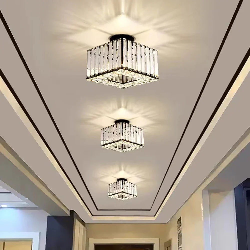 Three modern square crystal glass LED chandeliers arranged in a row, featuring ornate, decorative crystal designs.