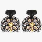 Round black metal chandelier with clear crystal accents and exposed bulb, semi-flush mount design.
