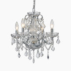 Ornate chrome chandelier with four candle bulbs and sparkling crystal prisms and beads.