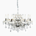 Maison Ornate French chandelier with 8 chrome arms, candle bulbs, clear prisms, silver chain.