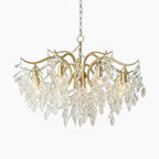 Maison Ornate 8-arm gold chandelier with curved arms, crystal leaves, and visible E12 bulbs.