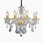 Ornate gold chandelier with maple leaf accents, six candles, and luxurious dangling K9 crystals.