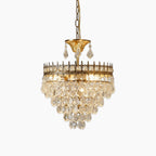 Ornate gold chandelier with hanging crystals, multiple tiers, and lit bulbs on a gold chain.