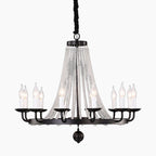 Black metal chandelier with candle bulbs and draped K9 crystal bead chains, suspended by black cord.