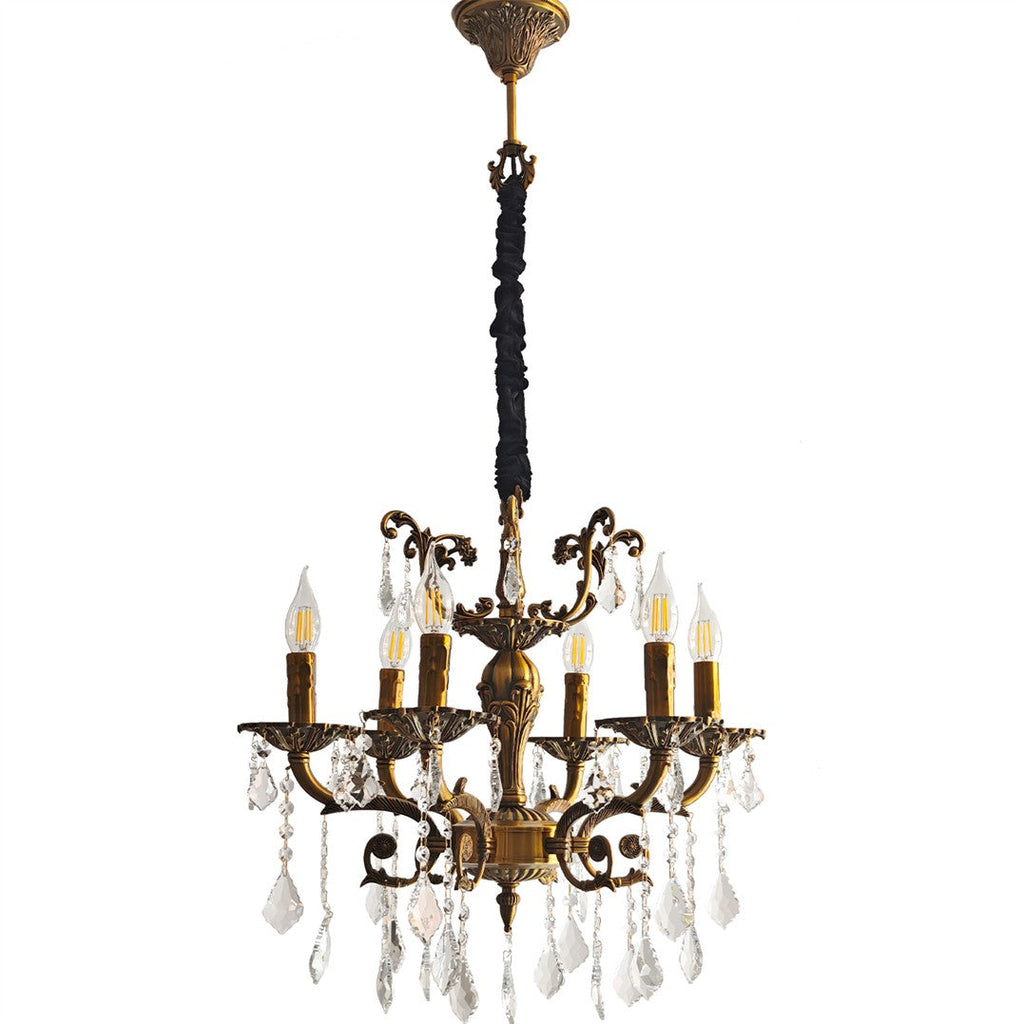 Brass chandelier with 12 ornate arms, candle-style bulbs, and crystal pendants, suspended by fabric chain.