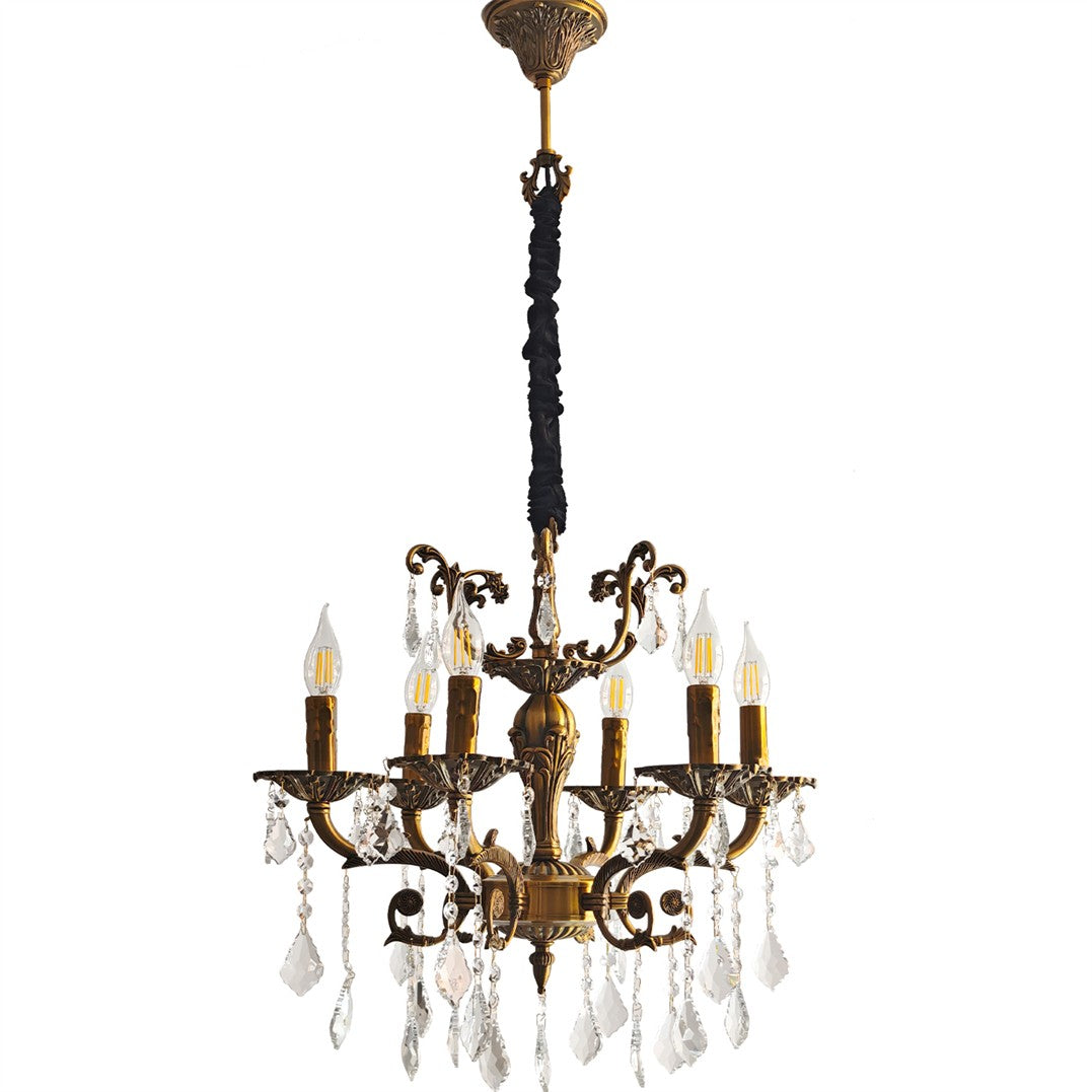 Brass chandelier with 12 ornate arms, candle-style bulbs, and crystal pendants, suspended by fabric chain.