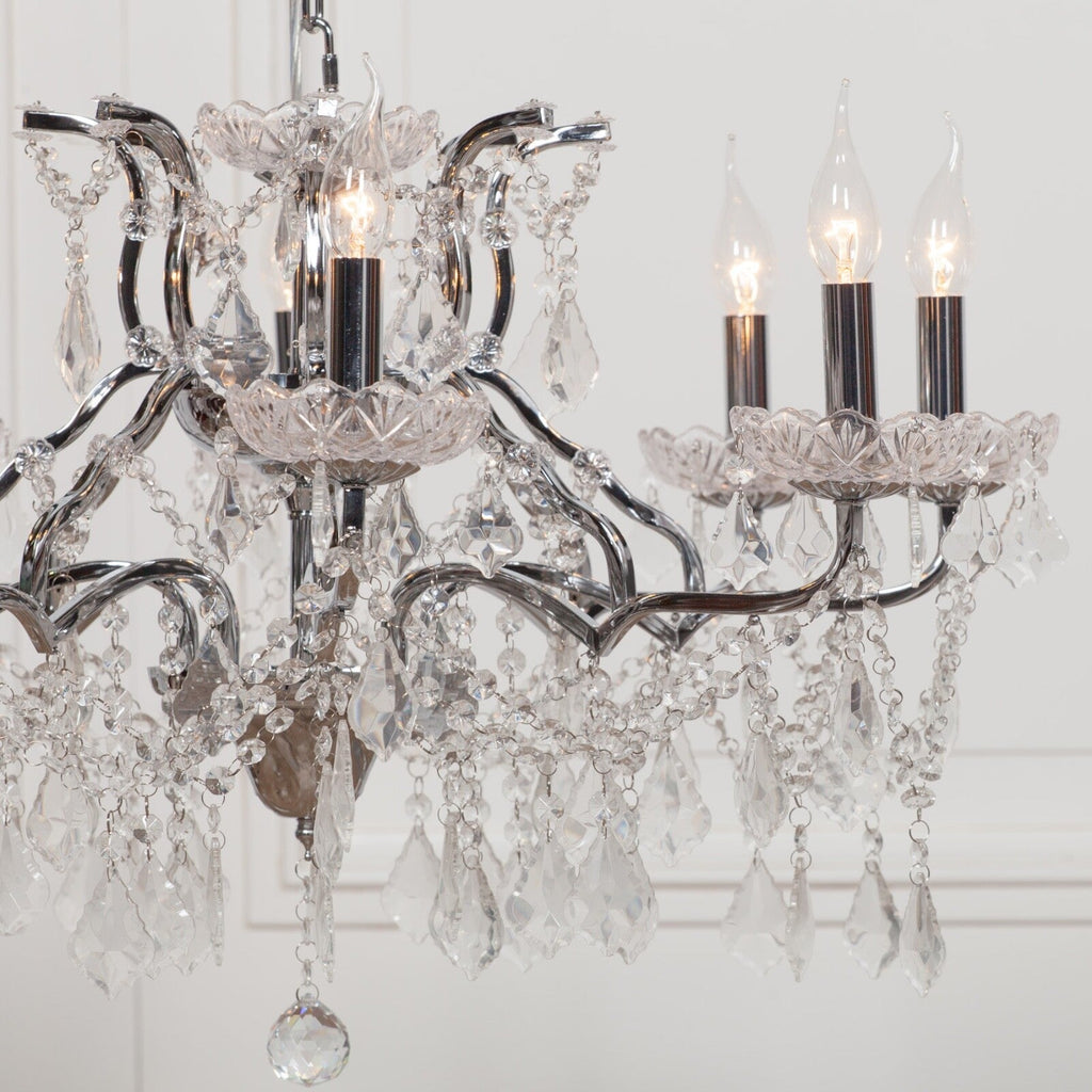 Maison Ornate French Style Crystal Chandelier with chrome arms, ornate metalwork, prisms, and candle bulbs.