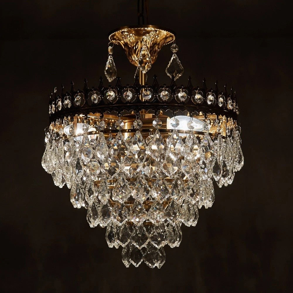 Luxurious gold chandelier with multiple crystal prism tiers, creating an elegant, sparkling centerpiece.