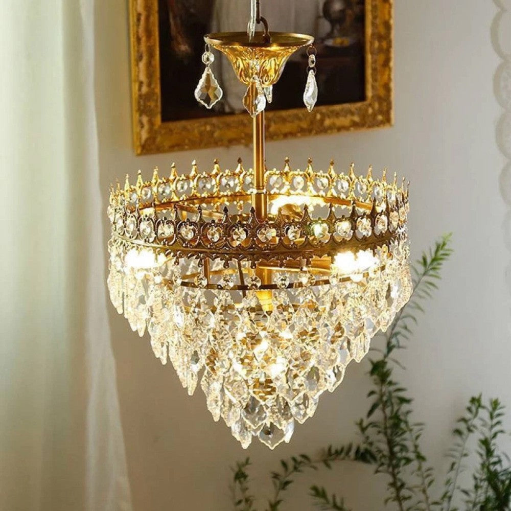 Maison Ornate chandelier with gold finishes and tiered crystals, beautifully illuminated, elegant modern design.