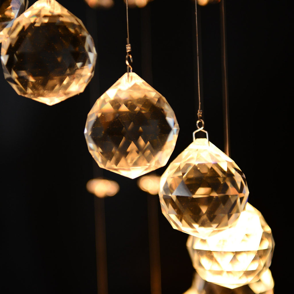 Maison Ornate Crystal Ball Chandelier features faceted glass balls on thin wires, warmly illuminated.
