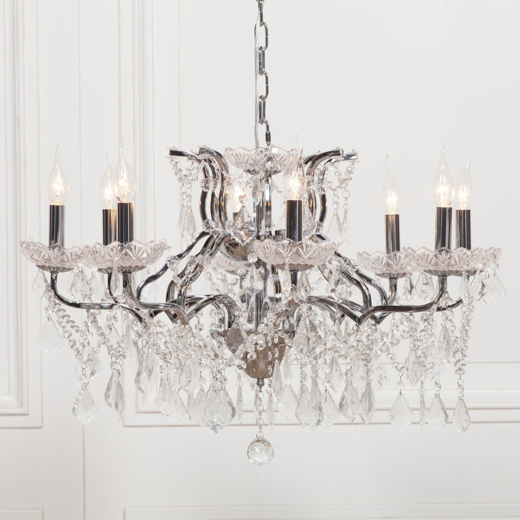 Maison Ornate French chandelier with 8 chrome arms, candle bulbs, and cascading crystal prisms.