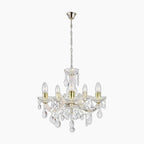 Five-arm chandelier with brass, acrylic arms, crystal droplets, and candle-style bulbs on chain.