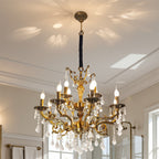 Maison Ornate antique brass chandelier with 12 arms, candle bulbs, and hanging crystal accents.
