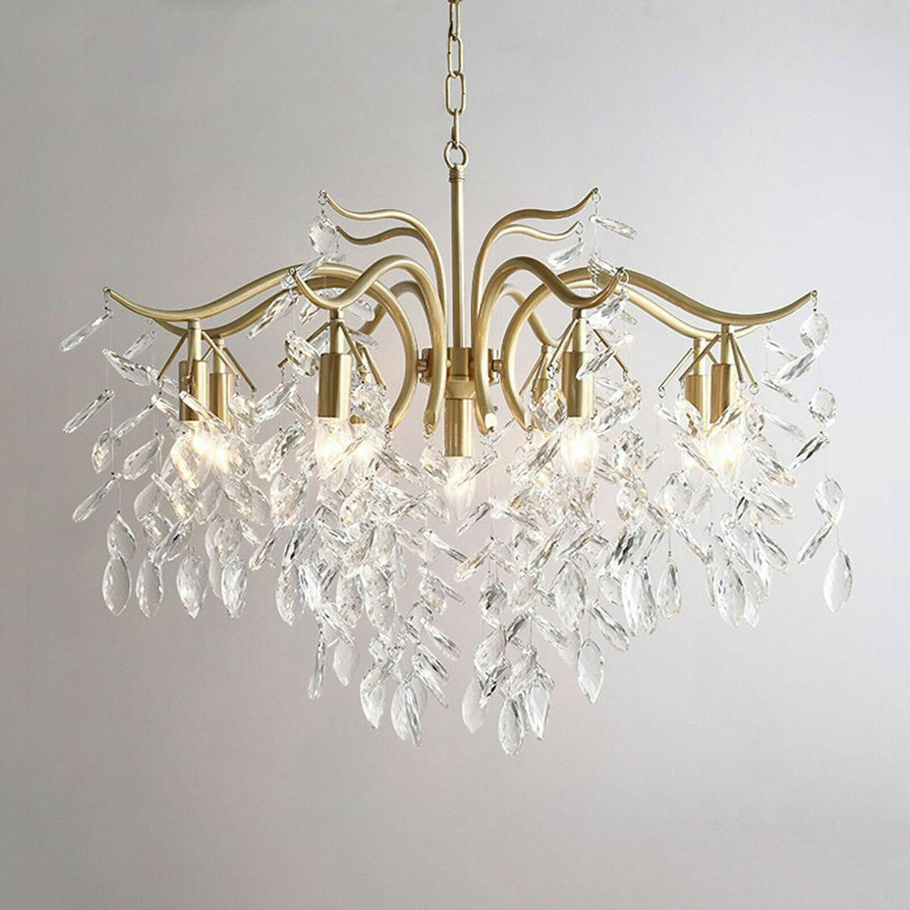 Elegant gold leaf-branch chandelier with eight arms, clear hanging crystals, and modern bulb illumination.