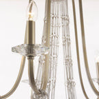 Maison Ornate Elegant chandelier with gold arms, candle-style bulbs, crystals, and faceted glass details.