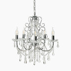 Five-light antique crystal chandelier with polished chrome arms and hanging clear crystals and chains.